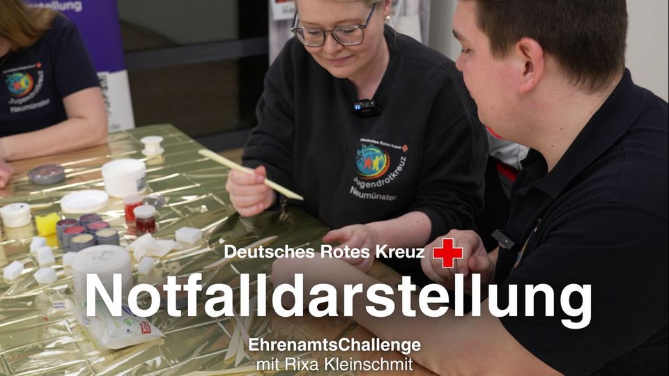 Eine Frau schminkt einem jungen Mann eine Fake-Wunde an der Hand.