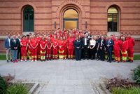 Gruppenbild: Rund 80 Personen stehen vor einem Backstein-Gebäude.
