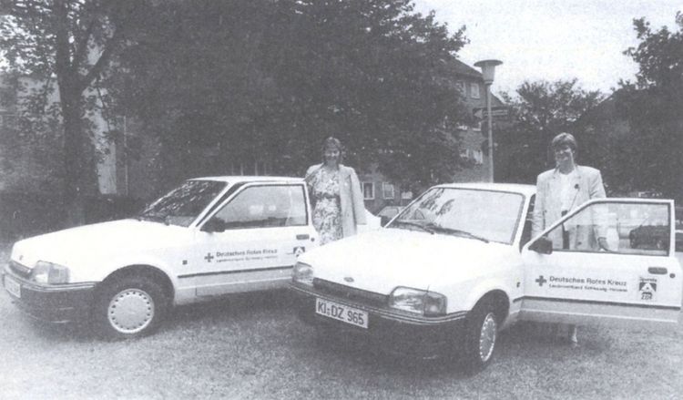 Zwei Frauen mit Einsatzfahrzeugen