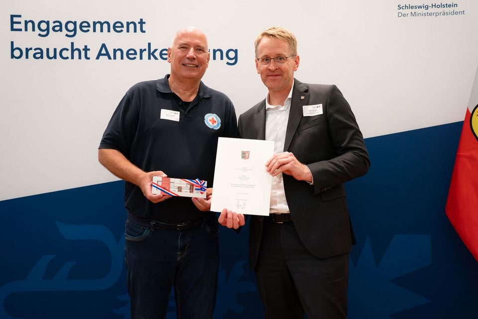 Zwei Personen stehen vor einer Foto-Wand auf der "Engagement braucht Anerkennung steht".