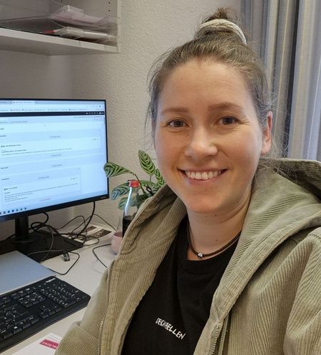 neue Mitarbeiterin lächelnd am Schreibtisch