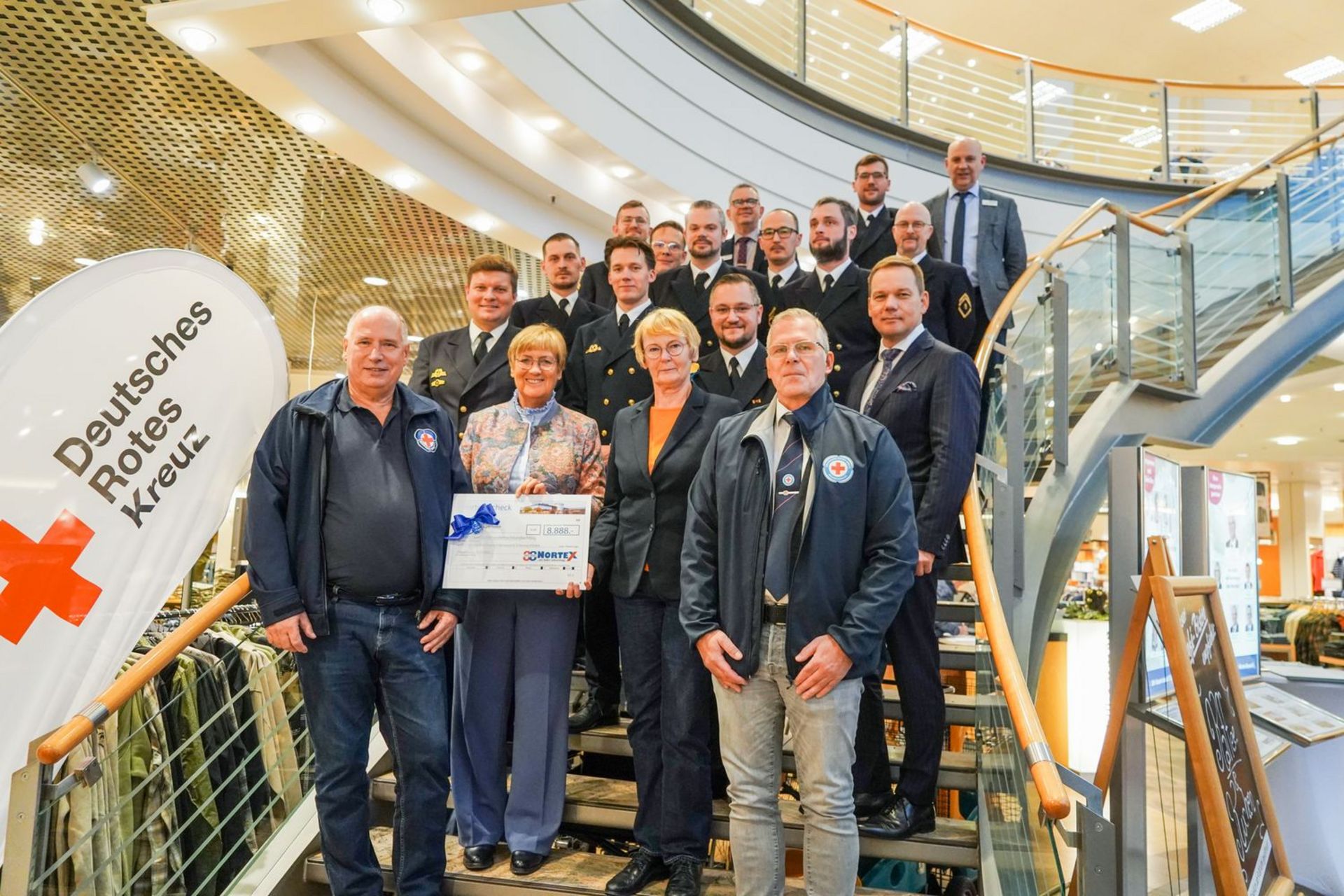 Ca. 20 Menschen stehen für ein Gruppenbild auf einer Treppe.