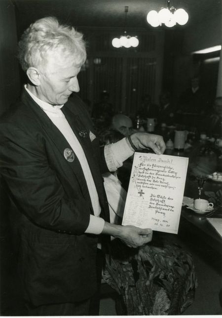 eine Frau mit einem Dankesbrief der Geflüchteten an die Mitarbeitenden des DRK