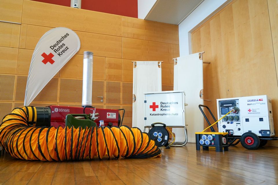 Mehrere weiße und rote metallische Maschinen mit DRK-Aufklebern stehen nebeneinander.
