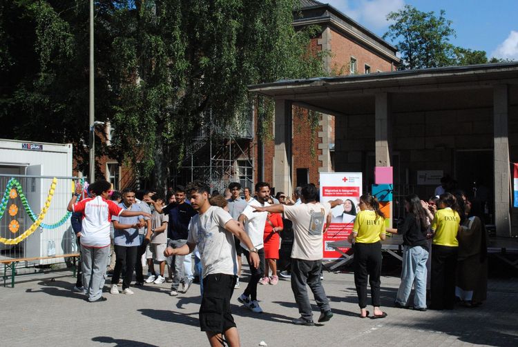 Rund 50 Personen tanzen vor einer Bühne.