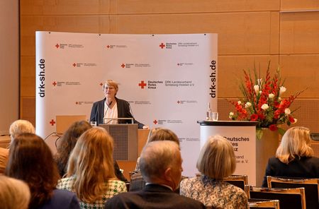 Die Vorsitzende des DRK-Landesverbandes Schleswig-Holstein, Anette Langner, spricht auf einer Veranstaltung vor mehreren Gästen.